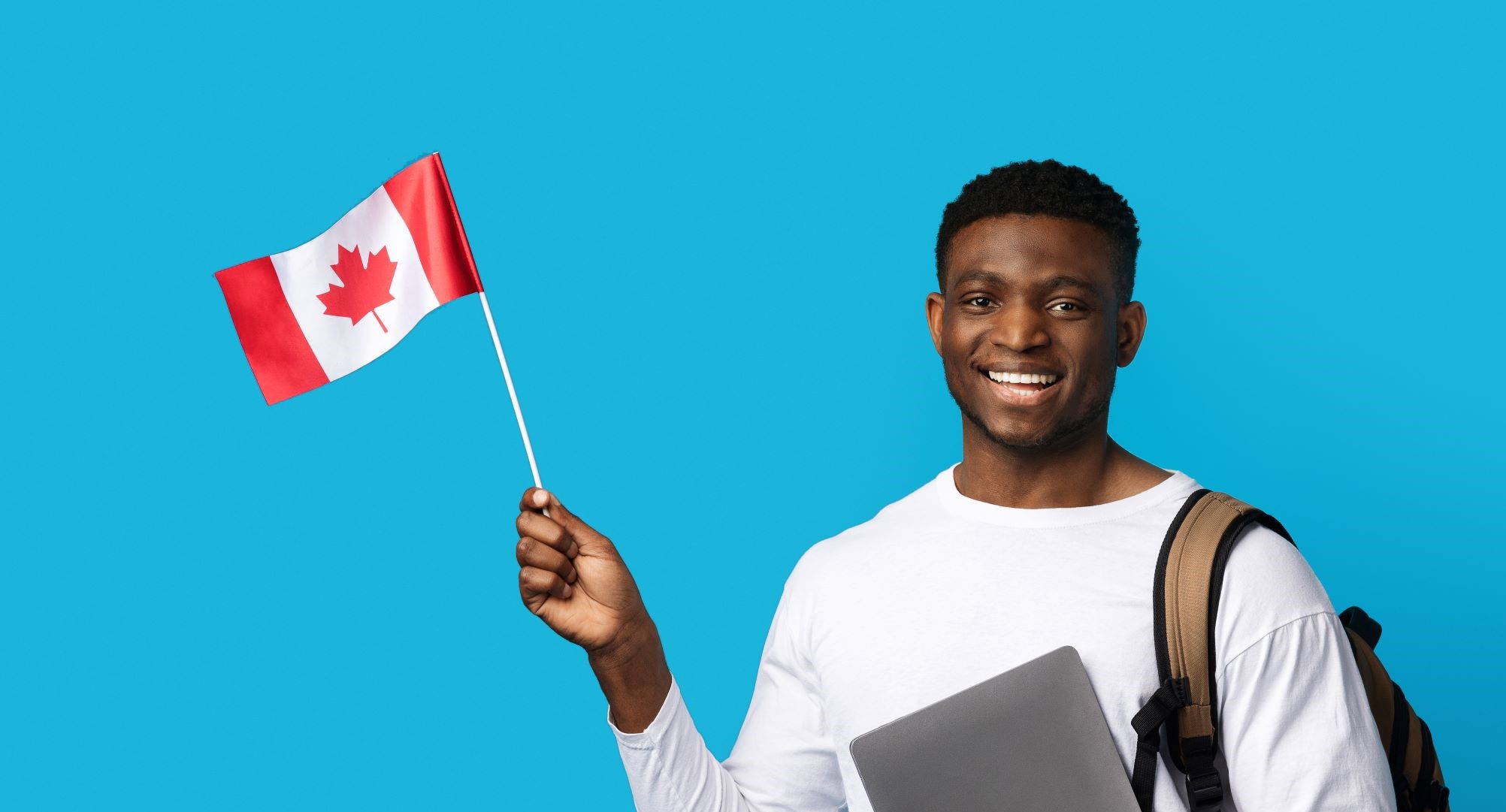 Positive african guy student holding laptop and Canadian flag